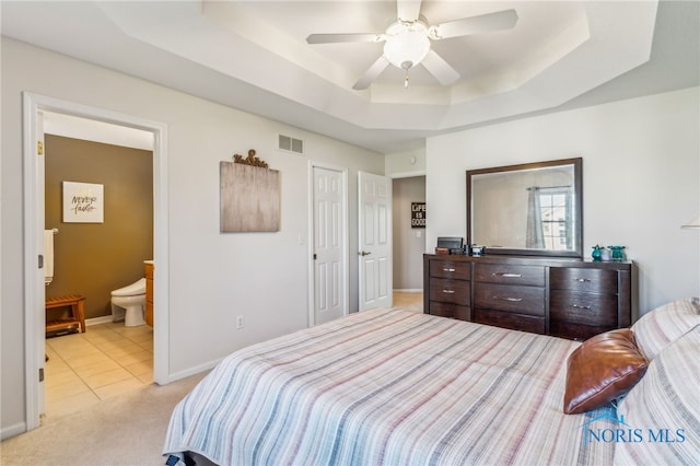 3112 Jacob Dr, Findlay, OH 45840 - bedroom featuring a tray ceiling, baseboards, ensuite bath, light colored carpet, and light tile patterned flooring