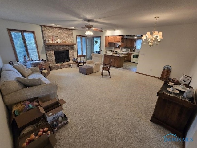 2111 Cobblestone Dr, Findlay, OH 45840 - living room featuring light colored carpet, a chandelier, healthy amount of natural light, and a brick fireplace