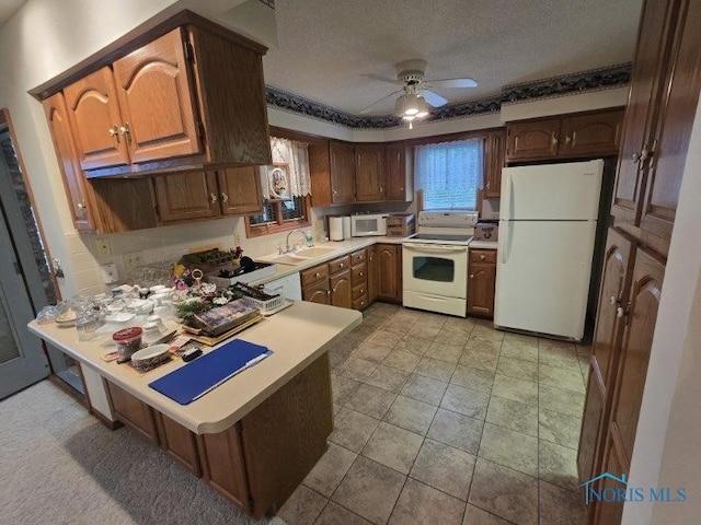 2111 Cobblestone Dr, Findlay, OH 45840 - kitchen featuring white appliances, a peninsula, a sink, a ceiling fan, and light countertops
