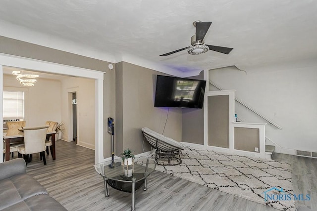 1129 Mason St, Toledo, OH 43605 - living room with wood finished floors, baseboards, a ceiling fan, a chandelier, and stairs