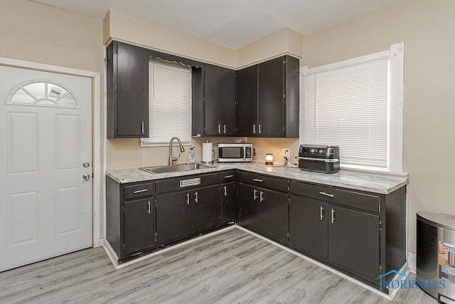 1129 Mason St, Toledo, OH 43605 - kitchen with a sink, stainless steel microwave, and light wood-style floors