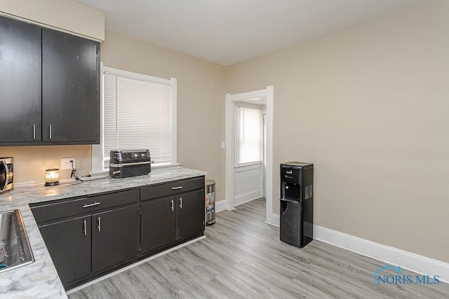 1129 Mason St, Toledo, OH 43605 - kitchen with light wood finished floors, baseboards, stainless steel microwave, and dark cabinetry