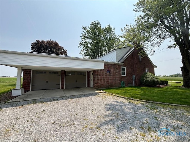 28335 Allen Rd, Defiance, OH 43512 - view of side of home with brick siding, an attached garage, a lawn, and driveway