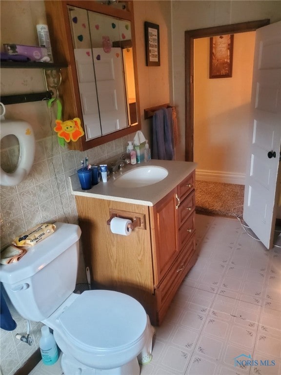 406 S State St, Pioneer, OH 43554 - bathroom with tile patterned floors, toilet, vanity, and tasteful backsplash