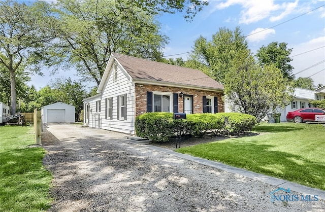 2101 Trailview Dr, Maumee, OH 43537 - view of front of property featuring driveway, an outbuilding, a front yard, a garage, and brick siding