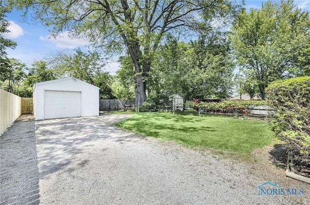 2101 Trailview Dr, Maumee, OH 43537 - view of yard featuring an outdoor structure, driveway, and a garage