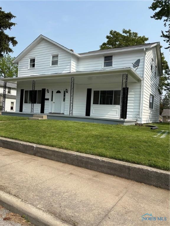 view of front facade with a front lawn and covered porch