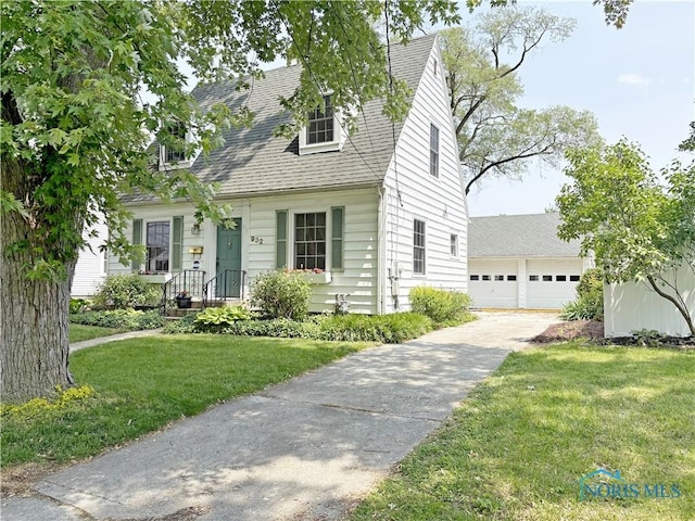 932 N Grove St, Bowling Green, OH 43402 - cape cod house featuring a front lawn and a garage