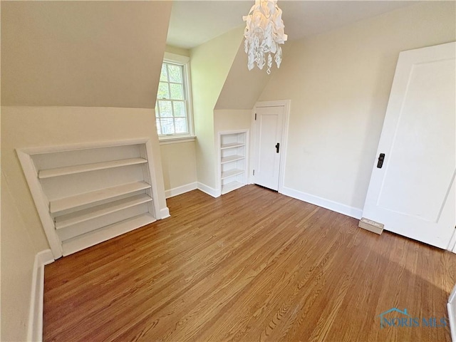 932 N Grove St, Bowling Green, OH 43402 - additional living space featuring built in features, baseboards, wood finished floors, a chandelier, and lofted ceiling