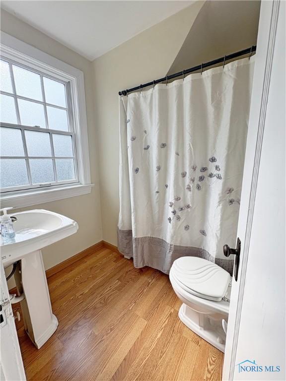 932 N Grove St, Bowling Green, OH 43402 - bathroom with wood finished floors, toilet, a shower with curtain, and baseboards
