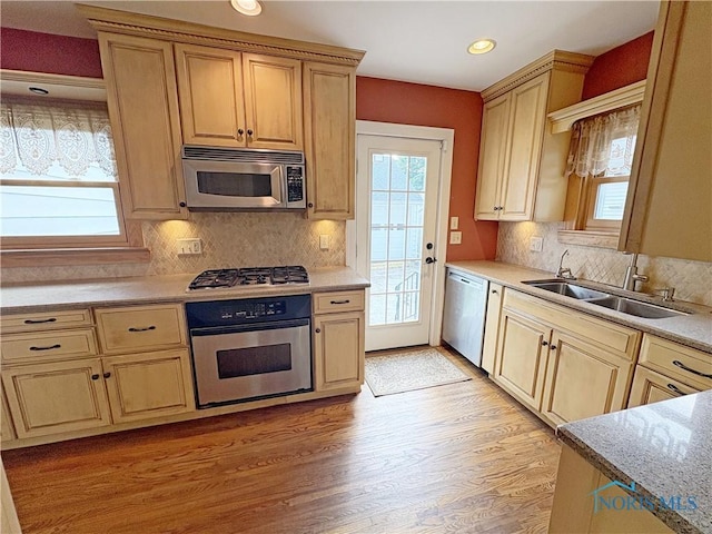 932 N Grove St, Bowling Green, OH 43402 - kitchen with appliances with stainless steel finishes, a sink, light wood-type flooring, tasteful backsplash, and recessed lighting