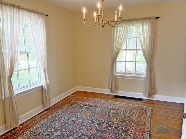 932 N Grove St, Bowling Green, OH 43402 - spare room featuring a chandelier, wood finished floors, and baseboards