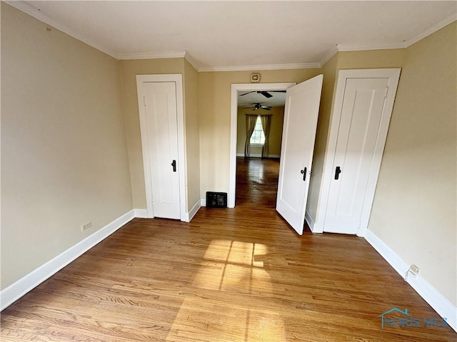 932 N Grove St, Bowling Green, OH 43402 - unfurnished bedroom with light wood-style flooring, baseboards, crown molding, and a closet