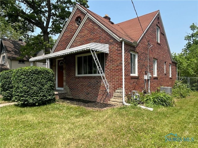 3030 Colby Dr, Toledo, OH 43614 - view of side of home with brick siding, a chimney, entry steps, and central air condition unit