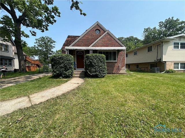 3030 Colby Dr, Toledo, OH 43614 - view of front facade with a front lawn, brick siding, and central air condition unit
