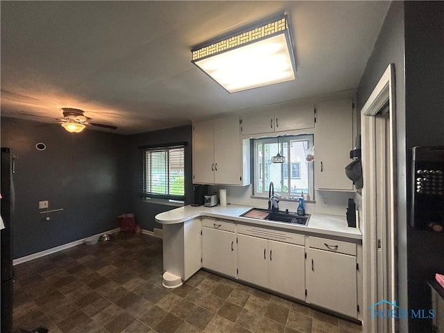 3030 Colby Dr, Toledo, OH 43614 - kitchen featuring a sink, light countertops, a peninsula, a ceiling fan, and white cabinets