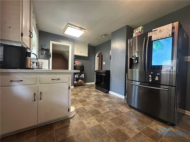 3030 Colby Dr, Toledo, OH 43614 - kitchen featuring stainless steel refrigerator with ice dispenser, black range, arched walkways, baseboards, and dark stone finish flooring