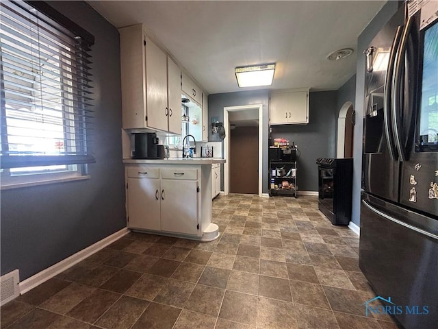 3030 Colby Dr, Toledo, OH 43614 - kitchen with refrigerator with ice dispenser, baseboards, light countertops, and white cabinetry