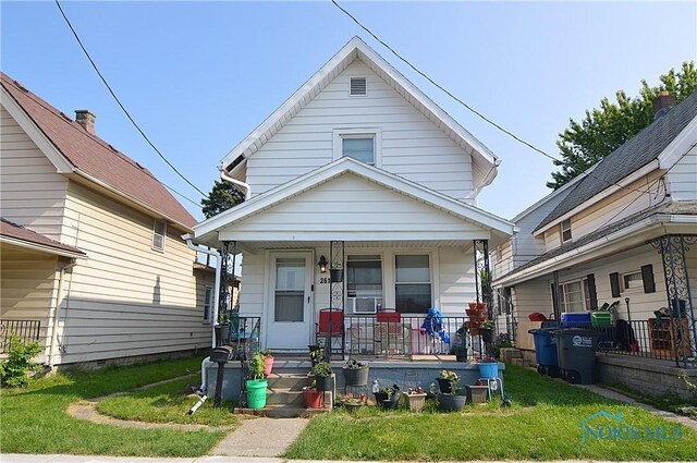 2617 York St, Toledo, OH 43605 - view of front of house with covered porch, a front yard, and cooling unit