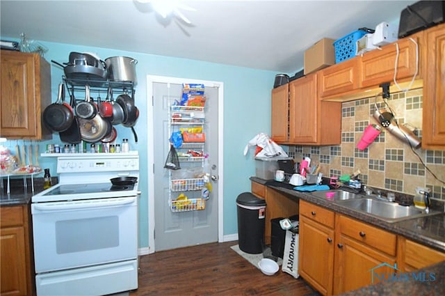 2617 York St, Toledo, OH 43605 - kitchen featuring white range with electric stovetop, backsplash, dark countertops, dark wood-style flooring, and a sink