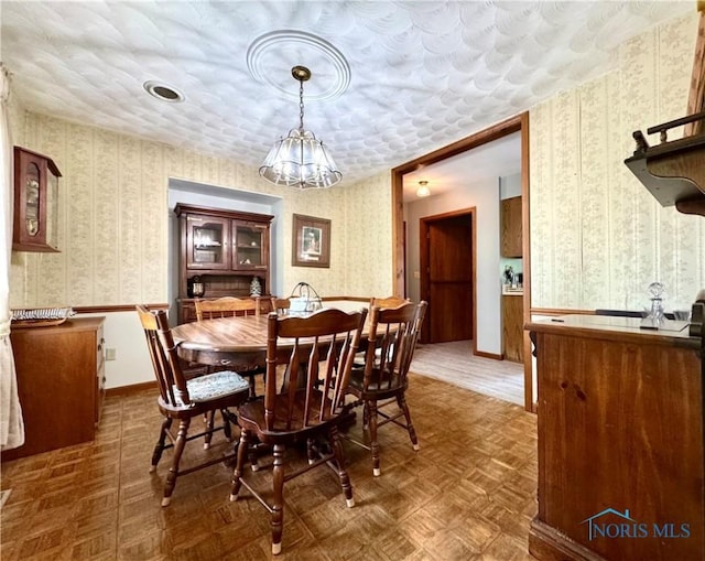 1508 Darbyshire Dr, Defiance, OH 43512 - dining area featuring wallpapered walls, a chandelier, and a wainscoted wall