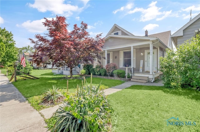 224 Elm St, Rossford, OH 43460 - view of front of house featuring covered porch, a front lawn, and a chimney