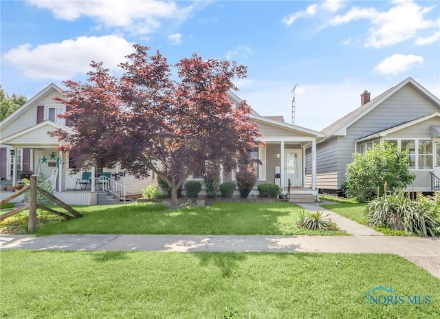 224 Elm St, Rossford, OH 43460 - view of front of house featuring covered porch and a front lawn