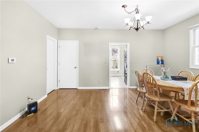 224 Elm St, Rossford, OH 43460 - dining space with a chandelier, healthy amount of natural light, wood finished floors, and baseboards