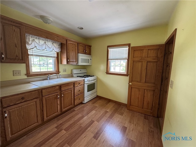 1001 Wilhelm St, Defiance, OH 43512 - kitchen featuring white appliances, a sink, light countertops, light wood finished floors, and brown cabinets
