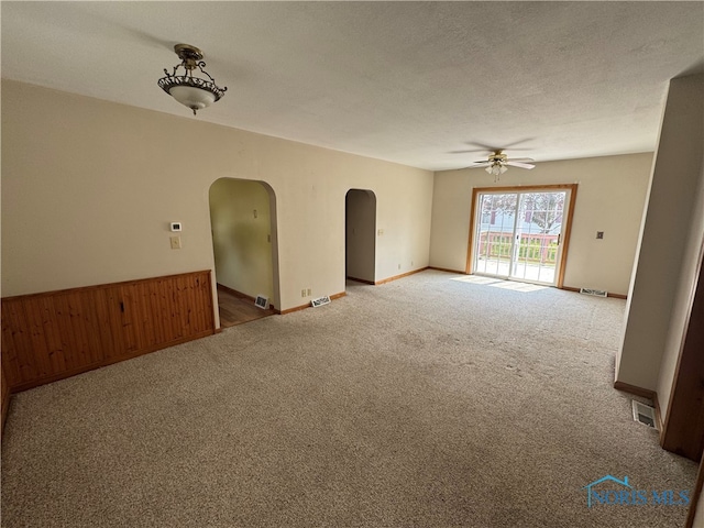 1001 Wilhelm St, Defiance, OH 43512 - empty room with arched walkways, carpet flooring, ceiling fan, a textured ceiling, and baseboards