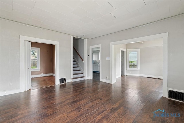 715 Nicholas St, Toledo, OH 43609 - unfurnished living room featuring healthy amount of natural light, stairway, wood-type flooring, and baseboards