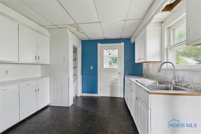 715 Nicholas St, Toledo, OH 43609 - kitchen featuring a sink, dark floors, a drop ceiling, light countertops, and white cabinets