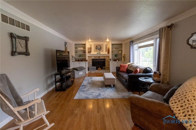 7663 Cortland Ct, Holland, OH 43528 - living area with a brick fireplace, crown molding, wood finished floors, built in features, and baseboards