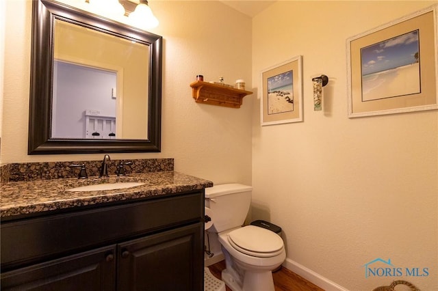 7663 Cortland Ct, Holland, OH 43528 - bathroom with toilet, baseboards, vanity, and wood finished floors