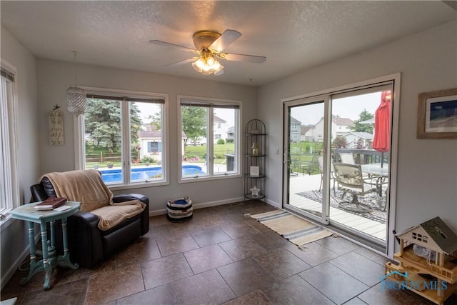 7663 Cortland Ct, Holland, OH 43528 - living area featuring baseboards, a ceiling fan, and a textured ceiling