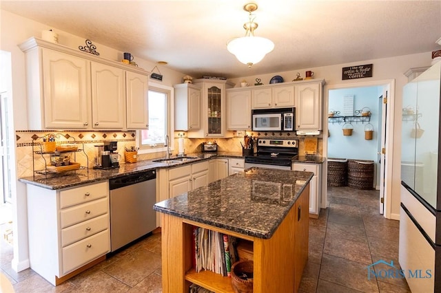 7663 Cortland Ct, Holland, OH 43528 - kitchen with stainless steel appliances, a sink, backsplash, open shelves, and glass insert cabinets