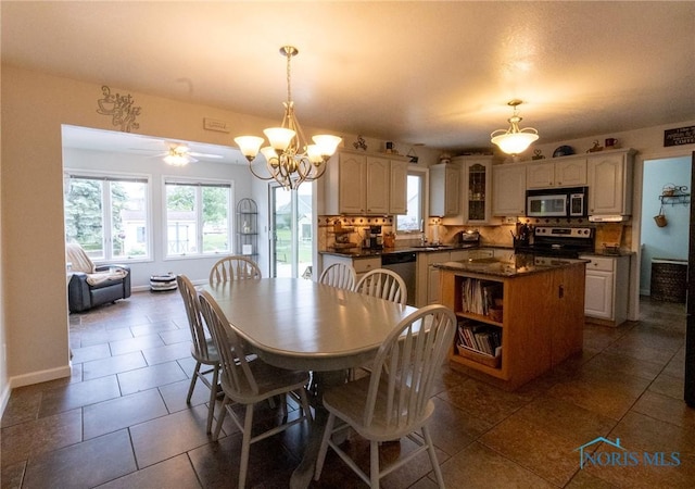7663 Cortland Ct, Holland, OH 43528 - dining area with a chandelier, dark tile patterned floors, baseboards, and ceiling fan