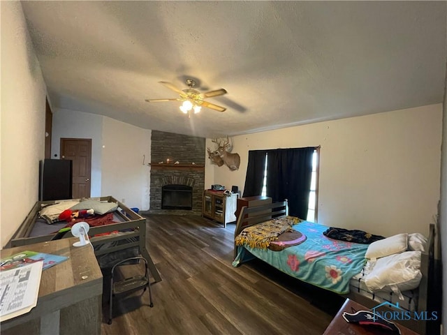 7774 Scott Rd, Edgerton, OH 43517 - bedroom featuring dark wood-style floors, a fireplace, ceiling fan, and a textured ceiling