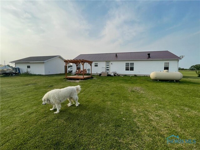 7774 Scott Rd, Edgerton, OH 43517 - back of house featuring a pergola, a yard, a wooden deck, and metal roof