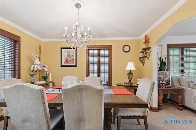 2917 Goddard Rd, Toledo, OH 43606 - dining room with a chandelier, crown molding, arched walkways, and carpet floors