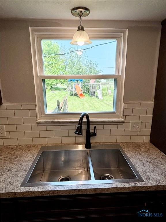 1105 S Lallendorf Rd, Oregon, OH 43616 - kitchen view of backsplash, hanging light fixtures, and light countertops