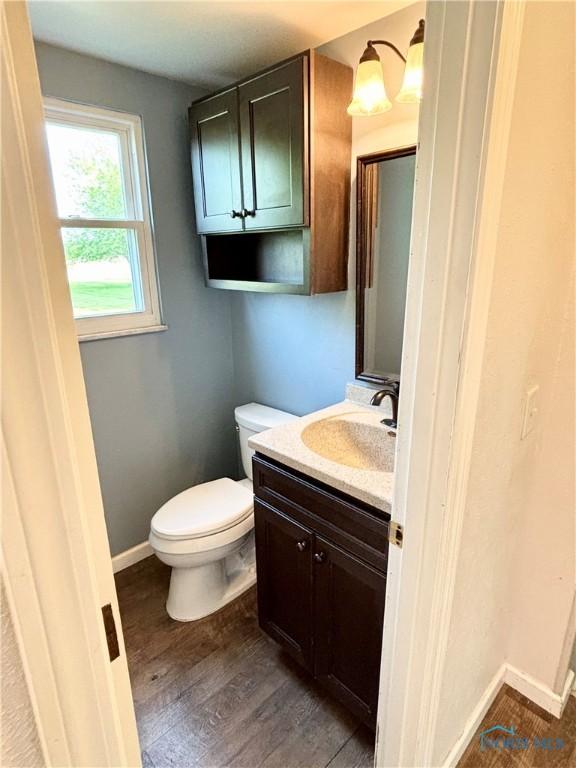 1105 S Lallendorf Rd, Oregon, OH 43616 - half bathroom with vanity and wood finished floors