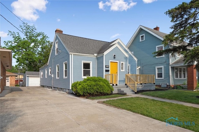 1006 Brookley Blvd, Toledo, OH 43607 - view of front facade featuring an outdoor structure, a chimney, a front yard, a garage, and roof with shingles