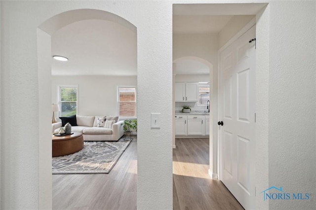 1006 Brookley Blvd, Toledo, OH 43607 - corridor with arched walkways, a sink, wood finished floors, and a textured wall
