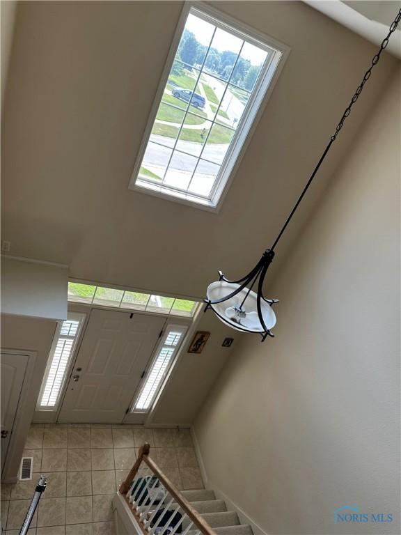 8828 Cedar Bend Rd, Sylvania, OH 43560 - foyer with healthy amount of natural light, light tile patterned floors, a high ceiling, and stairs
