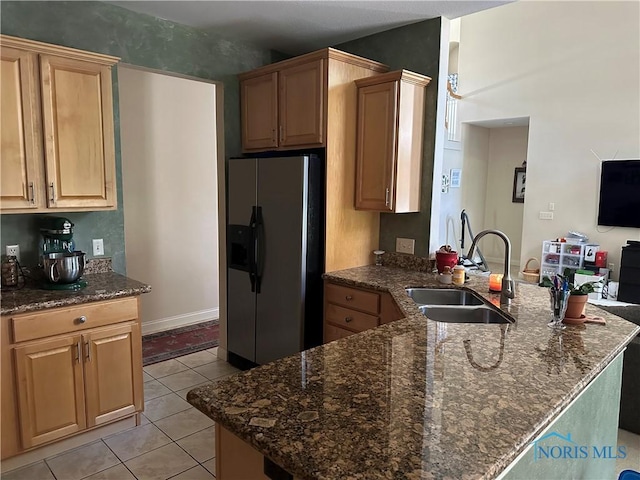 8828 Cedar Bend Rd, Sylvania, OH 43560 - kitchen featuring stainless steel fridge with ice dispenser, a peninsula, light tile patterned flooring, and dark stone countertops