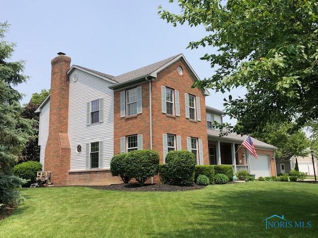 415 W Jamestown Ave, Tiffin, OH 44883 - view of side of home with a garage, a chimney, a yard, and brick siding