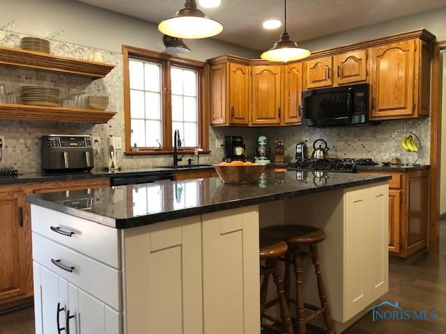 415 W Jamestown Ave, Tiffin, OH 44883 - kitchen with black appliances, a sink, tasteful backsplash, and a center island