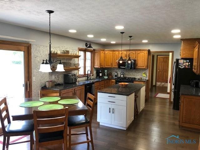 415 W Jamestown Ave, Tiffin, OH 44883 - kitchen featuring dark countertops, black appliances, brown cabinetry, a textured ceiling, and dark wood-style floors
