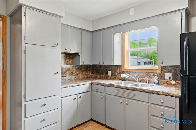 536 N Johnson St, Ada, OH 45810 - kitchen featuring freestanding refrigerator, gray cabinetry, a sink, and decorative backsplash